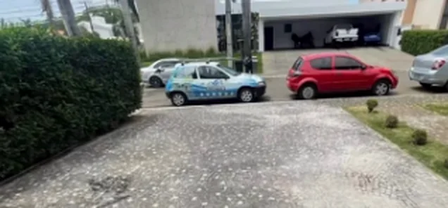 Entrada de garagem em pedra com a superfície esbranquiçada e manchada.