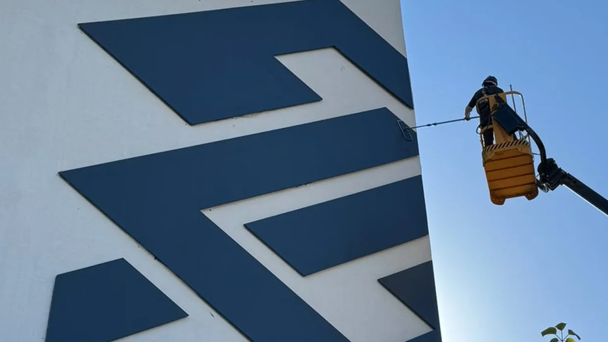 Operador em plataforma elevatória lavando a fachada de um prédio comercial em Palmas.