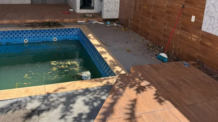 Área de piscina logo após a obra: água esverdeada, entulho e folhas espalhados pelo deck.
