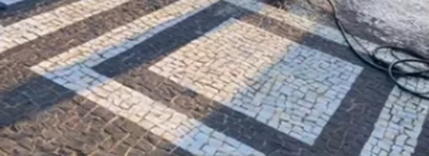 O mesmo piso de pedra portuguesa limpo, com o contraste do desenho preto e branco recuperado.